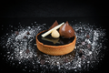 Chocolate dessert with a tartlet on a dark surface