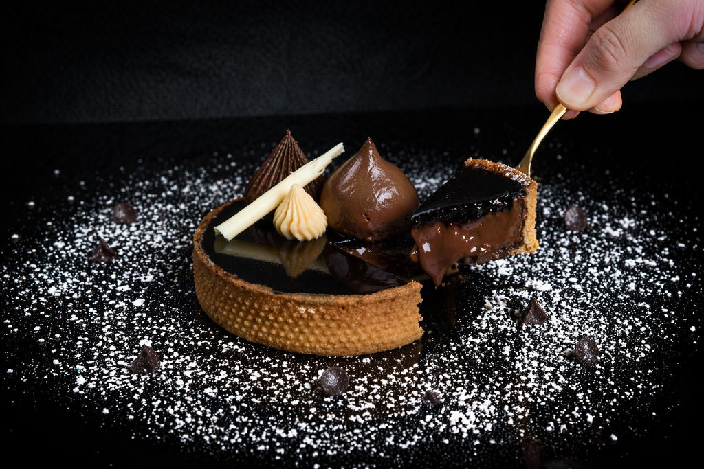 Chocolate dessert with a hand using a spoon to serve it on a dark background
