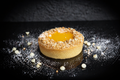 Mango and white choc tarte on a black background